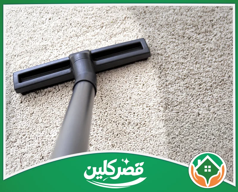 تنظيف سجاد للمنازل الكبيرة والفلل بالرياض 0550575548 قصر كلين رأس مكنسة كهربائية تنظف سجادة رمادية، وتظهر بوضوح خطاً فاصلاً يبرز الفارق الكبير بين الجزء النظيف والمتسخ.