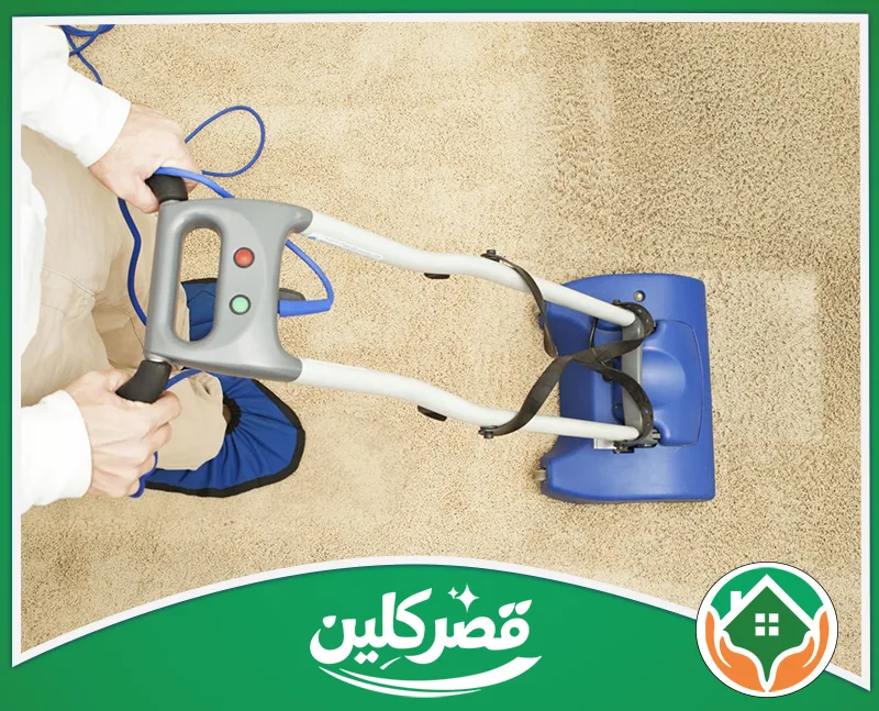 تعقيم سجاد بالرياض 0550575548 قصر كلين شخص يرتدي واقي حذاء أزرق ويستخدم آلة تنظيف احترافية لتنظيف السجاد بدقة، ويظهر بوضوح الفارق قبل وبعد التنظيف.