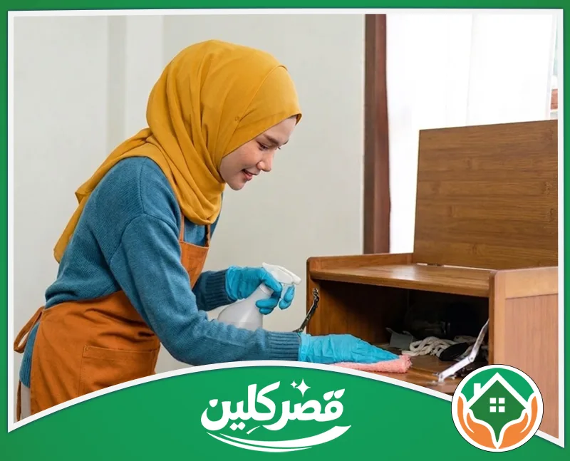 شركة تنظيف منازل بالرياض بالساعة نساء - قصر كلين عاملة متخصصة تنظف الأسطح الداخلية لخزانة خشبية باستخدام أدوات تنظيف مناسبة.