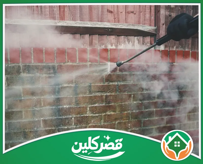 تنظيف واجهات حجر الرخام بالرياض 0550575548 قصر كلين شخص يرتدي قفازاً وينظف جداراً قرميدياً.