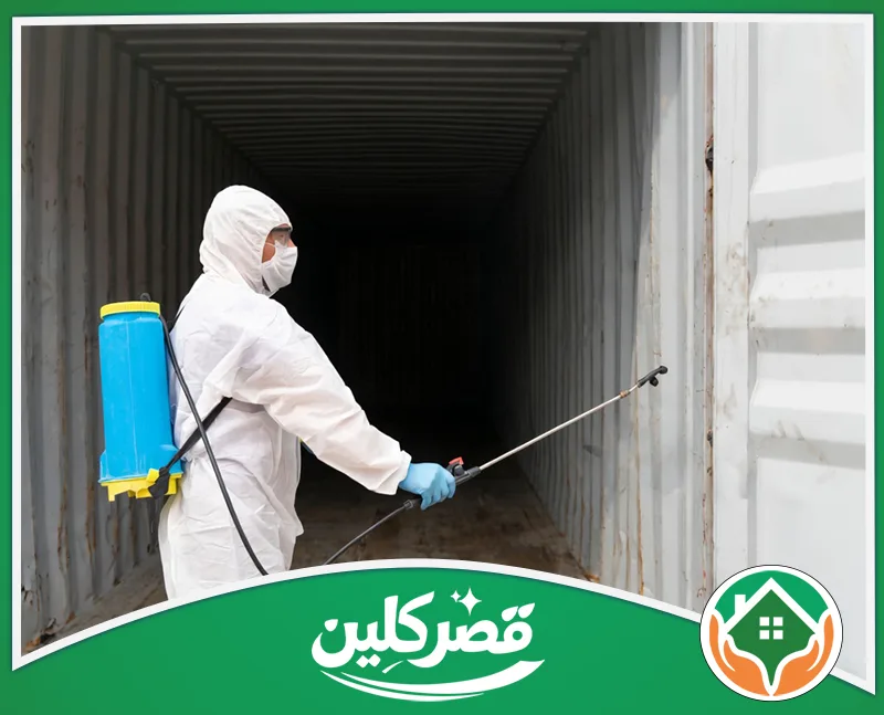 مكافحة العتة في الخزائن والمطابخ بالرياض 0550575548 قصر كلين شخص يرتدي بدلة واقية كاملة ويحمل مضخة زرقاء، يقوم بتطهير وتعقيم حاوية شحن لضمان سلامة البضائع ونظافتها.