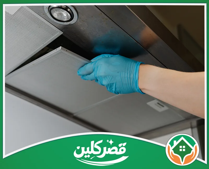 تنظيف مواسير سحب الدخان بالرياض 0550575548 قصر كلين فك وتركيب فلاتر شفاط المطبخ المعدنية لإجراء الصيانة أو التنظيف، بيد ترتدي قفازاً أزرق لحمايتها.