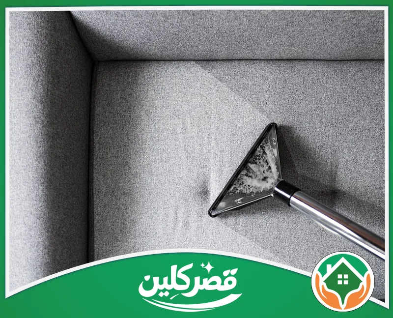 غسيل كنب في الرياض 0550575548 قصر كلين مكنسة تنظيف عميق على سطح كنبة قماشية رمادية، وتبرز الفارق بين الجزء النظيف وغير النظيف