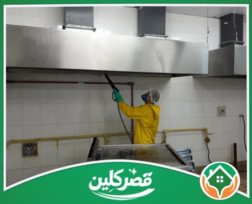 تنظيف هود المطاعم بالرياض - قصر كلين عامل يرتدي معدات حماية أثناء غسل هود مطعم وإزالة الدهون من أسطحه الداخلية والخارجية.